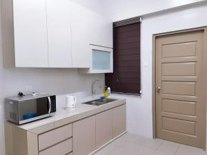 una cucina con lavandino e forno a microonde di [FREE WI-FI]Travelers Homestay Sitiawan[6~10Pax]The Venus Apartment a Sitiawan