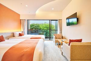 a hotel room with two beds and a flat screen tv at WeBase KAMAKURA in Kamakura