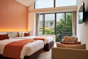 a hotel room with two beds and a window at WeBase KAMAKURA in Kamakura