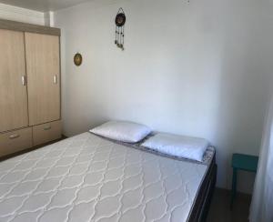 1 dormitorio con 1 cama blanca en una habitación en Dell Agnello, en Meia Praia