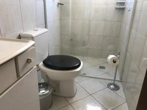 a bathroom with a toilet with a black seat at Dell Agnello in Perequê +16 photos