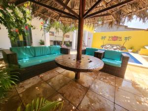 a patio with a couch and a table and chairs at pousada Amarante praia 1 in São Miguel do Gostoso