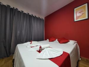 two beds in a room with red walls at pousada Amarante praia 1 in São Miguel do Gostoso