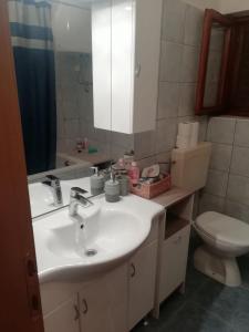a bathroom with a sink and a toilet and a mirror at Apartment Stomorska 8650a in Stomorska