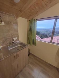 La salle de bains est pourvue d'un lavabo et d'une grande fenêtre. dans l'établissement La Casita de Chocolate 3, à Bogotá