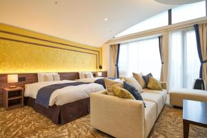 a hotel room with two beds and a couch at WeBase KAMAKURA in Kamakura