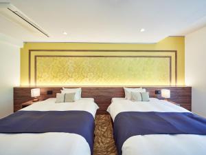 two beds in a room with a large window at WeBase KAMAKURA in Kamakura
