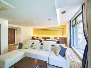 a living room with a couch and two beds at WeBase KAMAKURA in Kamakura