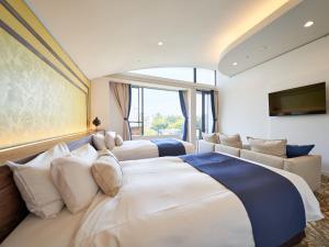 a hotel room with two beds and a couch at WeBase KAMAKURA in Kamakura