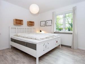 biała sypialnia z białym łóżkiem i oknem w obiekcie Holiday home Nordborg XXV w mieście Nordborg