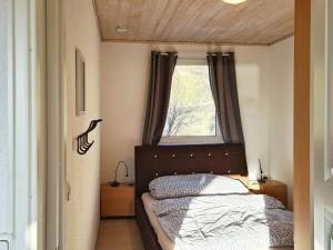 Habitación pequeña con cama y ventana en Holiday home LONEVÅG, en Lonevåg