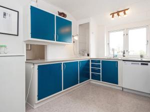 a blue and white kitchen with blue cabinets at Holiday home Nordborg XXV in Nordborg