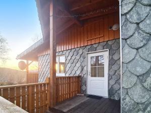 Casa con porche de madera y puerta blanca en Holiday home LONEVÅG, en Lonevåg