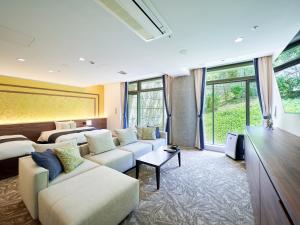 a living room with white couches and a large window at WeBase KAMAKURA in Kamakura