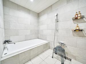 a bathroom with a bath tub and a sink at WeBase KAMAKURA in Kamakura