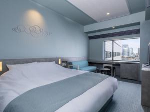a hotel room with a bed and a desk and a window at La Vista Tokyo Bay in Tokyo