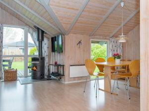 a dining room with a table and a wood stove at 8 person holiday home in Sydals-By Traum in Neder Lysabild