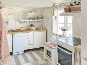 a kitchen with white cabinets and a stove top oven at Holiday home Vingåker III in Vingåker