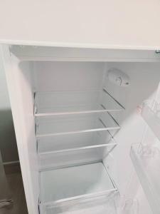 un réfrigérateur blanc vide avec sa porte ouverte dans l'établissement Cosy appartement Pierrefitte sur seine proche Paris "Appart'1", à Pierrefitte-sur-Seine