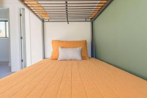 a large bed in a room with a pillow on it at Lux Modern Barnhouse Cabin at Hunter Mountain in Hunter