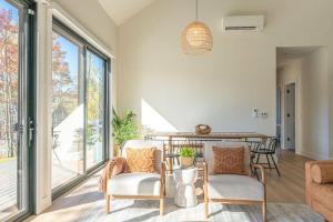 a living room with two chairs and a table at Lux Modern Barnhouse Cabin at Hunter Mountain in Hunter