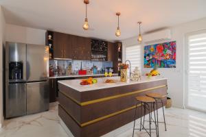 Una cocina con refrigerador y una encimera con taburetes. en Villa Srdella, en Podstrana