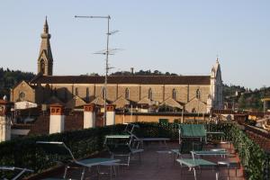 un gruppo di sedie seduti di fronte a un edificio di Hotel Bodoni a Firenze