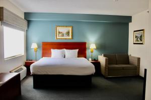 a hotel room with a bed and a chair at Reston Inn & Suites in Spencer +83 photos