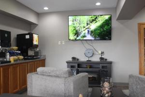a living room with two chairs and a television on the wall at Reston Inn & Suites in Spencer