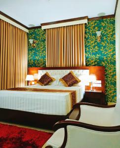 sypialnia z dużym łóżkiem i zieloną tapetą w obiekcie Hotel Crystal Rose - Sylhet w mieście Srihotto