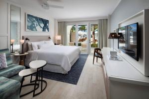 a hotel room with a bed and a living room at The Westin Grand Cayman Seven Mile Beach Resort & Spa in George Town