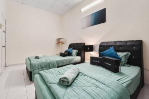 2 camas en una habitación con sábanas verdes y almohadas azules en Welcome to Happy 35, Old Klang Road, 10mins to Midvalley ! en Kuala Lumpur