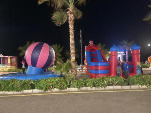 einen Vergnügungspark mit einem großen aufblasbaren Ball und einem Spielplatz in der Unterkunft بورتو سعيد وحدات in `Ezbet Shalabi el-Rûdi