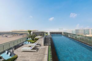 a large swimming pool on a building next to a beach at Fairfield by Marriott Mumbai International Airport in Mumbai