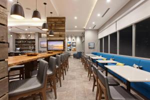 uma sala de jantar com mesas longas e cadeiras em SpringHill Suites by Marriott Huntington Beach Orange County em Huntington Beach