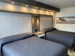 1 dormitorio con 2 camas y un cuadro en la pared en Travelodge by Wyndham Drummondville, en Drummondville