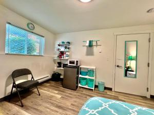a room with a bed and a chair and a microwave at Studio Apartment with Shared Bathroom 10 minutes walk to University of WA in Seattle