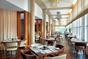 um restaurante com mesas e cadeiras de madeira e janelas em Sheraton Grand Hotel & Spa em Edimburgo