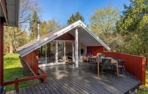 a house with a deck with a table and chairs at Beautiful Home In Munke Bjergby With Kitchen in Munke Bjergby