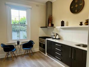 a kitchen with black and white appliances and a table at Villa on Melbourne St in Adelaide