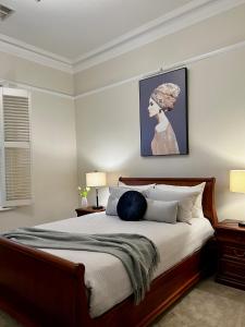 1 dormitorio con 1 cama grande con una foto en la pared en Villa on Melbourne St en Adelaida