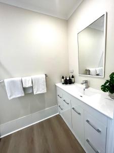 y baño con lavabo blanco y espejo. en Villa on Melbourne St en Adelaida