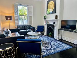 a living room with a couch and a fireplace at Villa on Melbourne St in Adelaide