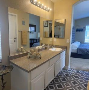 uma casa de banho com um lavatório e um espelho grande em Gorgeous home away from home em Las Vegas