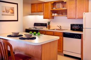 a kitchen with wooden cabinets and a white refrigerator at Residence Inn by Marriott Portland South-Lake Oswego in Lake Oswego