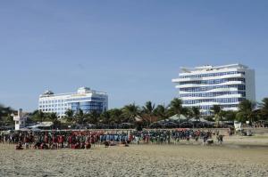 a crowd of people on a beach with buildings in the background at Nguyễn Kim Motel in Long Hai