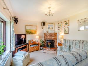 a living room with a couch and a fireplace at Langford Cottage in Ringstead