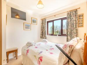 a bedroom with a bed and a window at Langford Cottage in Ringstead
