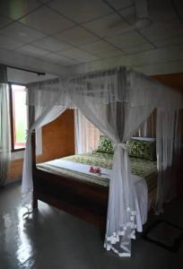a bed with a canopy in a bedroom at Gray house up in Weligama