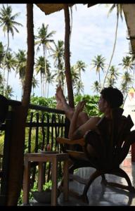 a woman sitting in a chair on a porch at Gray house up in Weligama +15 photos